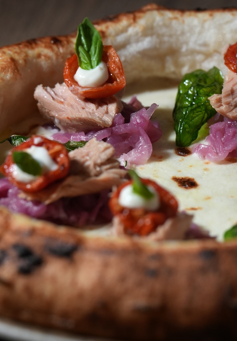 Pizza napoletana appena sfornata su tavolo in legno